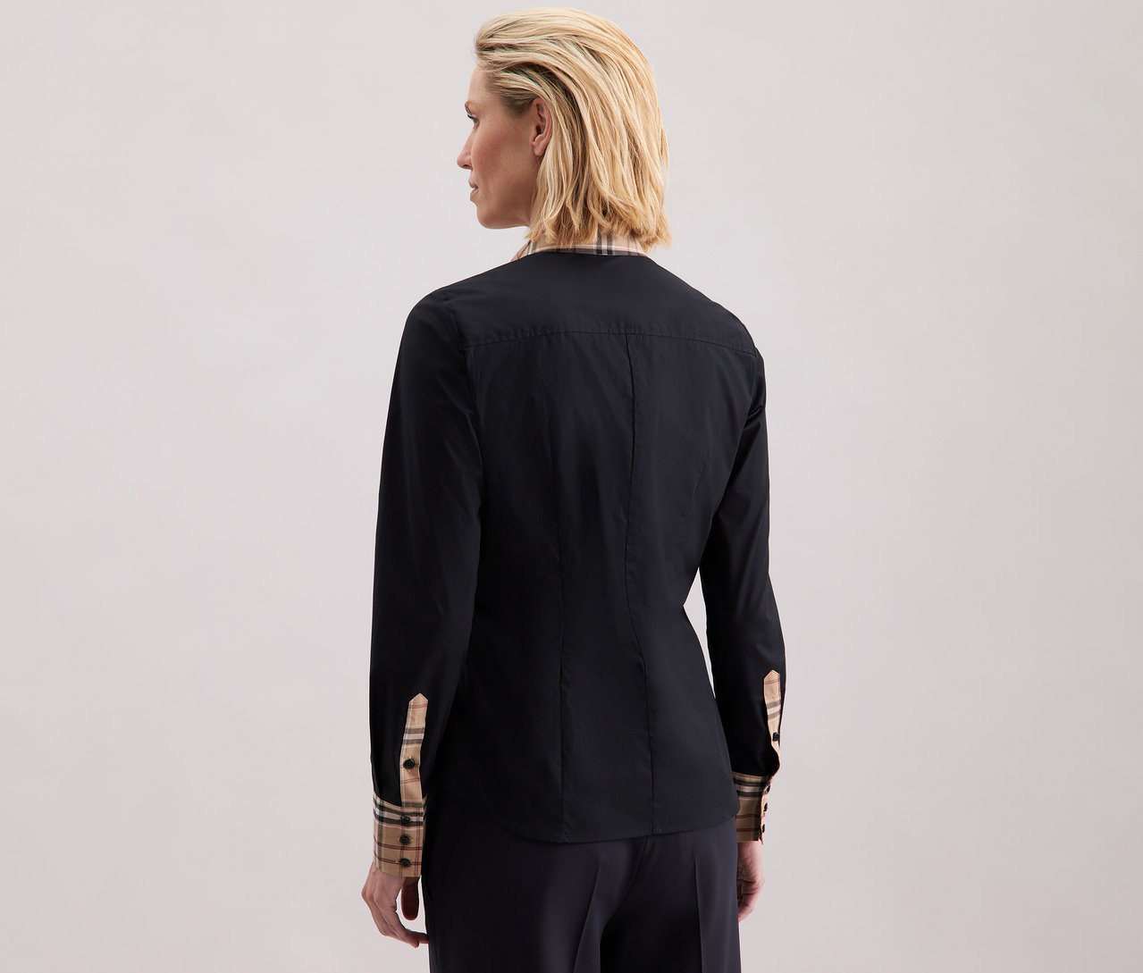 Une femme porte une chemise en popeline à carreaux Seidensticker.