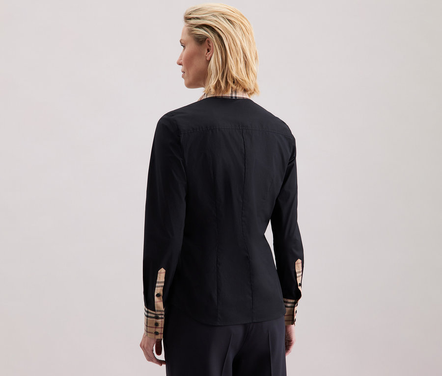 Une femme porte une chemise en popeline à carreaux Seidensticker.