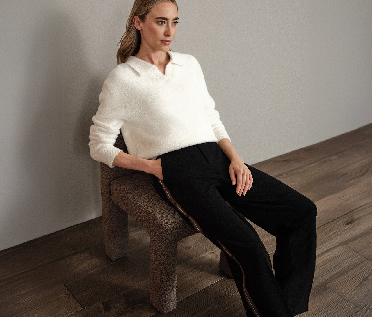 Femme assise sur une chaise portant un pull en maille à col polo Street One blanc.
