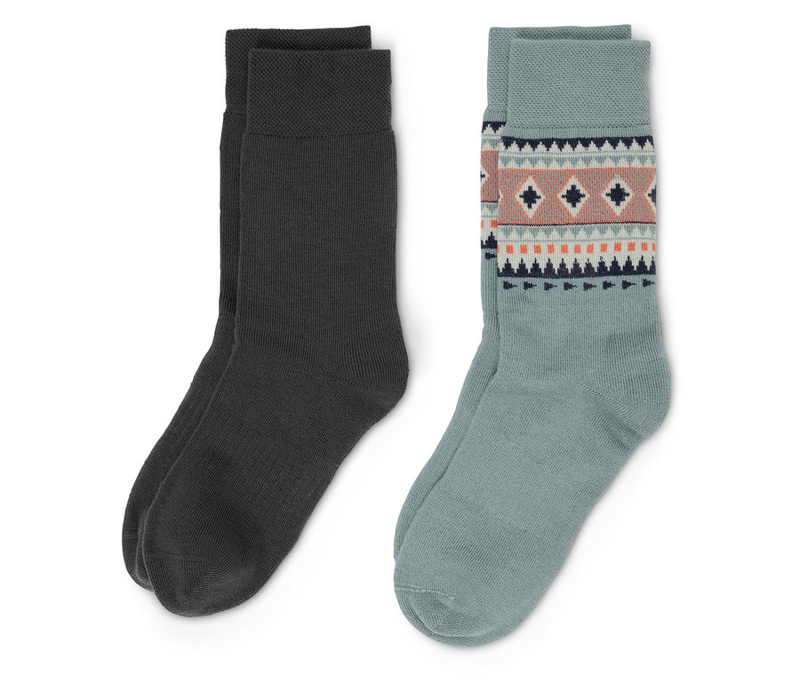 Deux paires de chaussettes. Une paire est gris foncé, l'autre paire est bleu clair avec un motif géométrique.