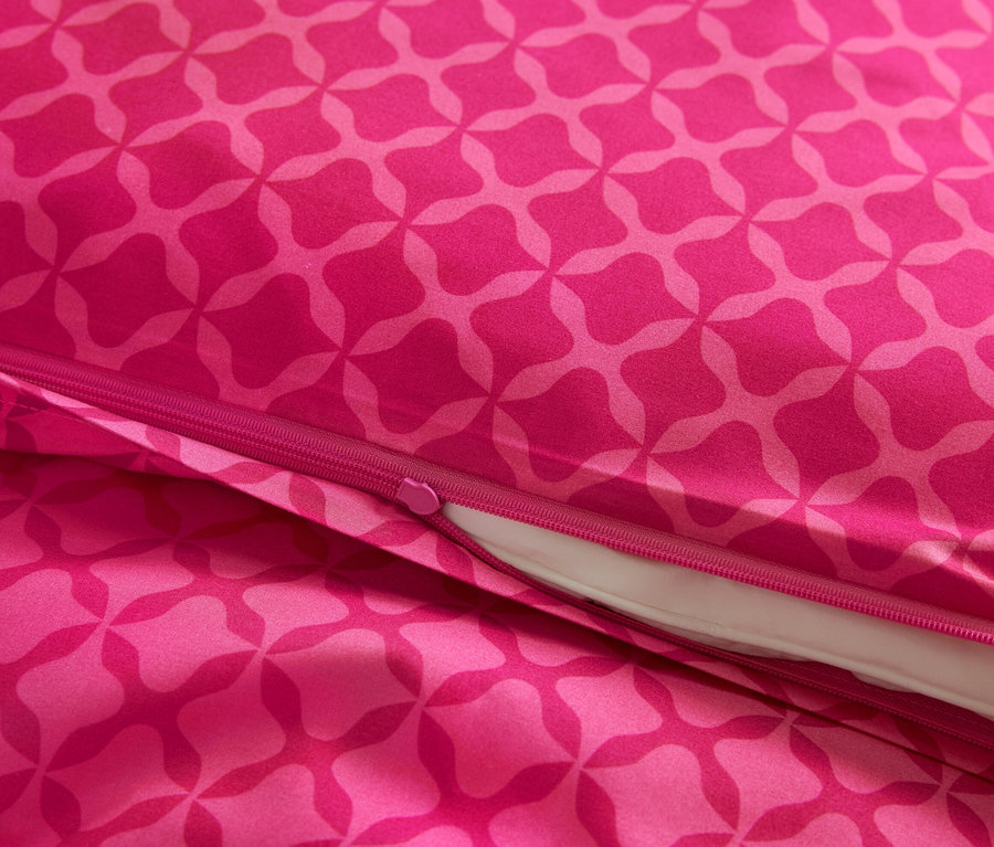 Gros plan d'une parure de lit en microfibre rose avec motif et fermeture éclair.
