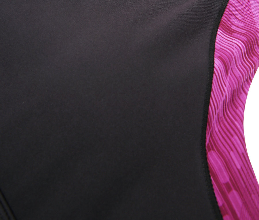 Gros plan d'un soutien-gorge de sport Fila noir avec un motif rose sur les bretelles et le décolleté.