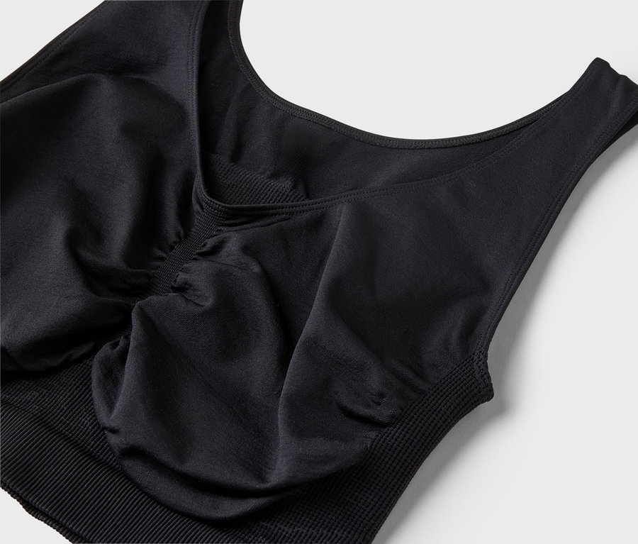 Vue détaillée d'un soutien-gorge de sport noir sur fond blanc.