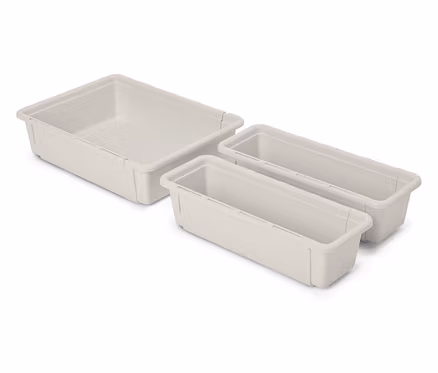 Trois organiseurs de tiroirs en plastique beige vides reposent sur un fond blanc.