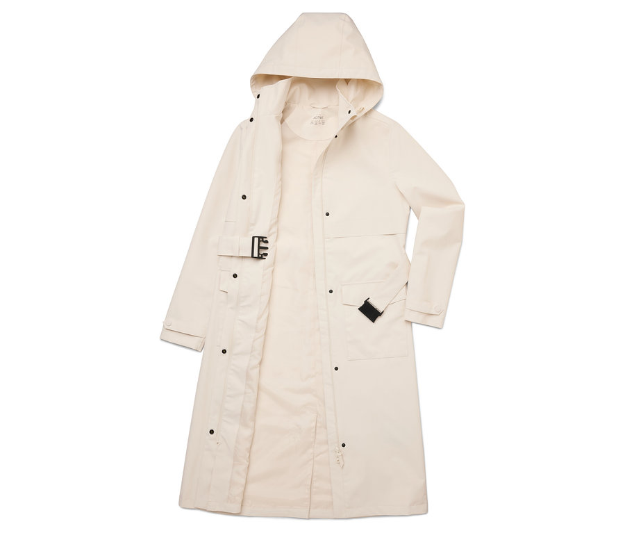 Imperméable long crème ouvert avec capuche, fermeture boutonnée et ceinture posé à plat sur le sol.