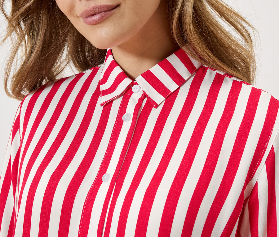Gros plan d'une femme portant une chemise rayée rouge et blanche.