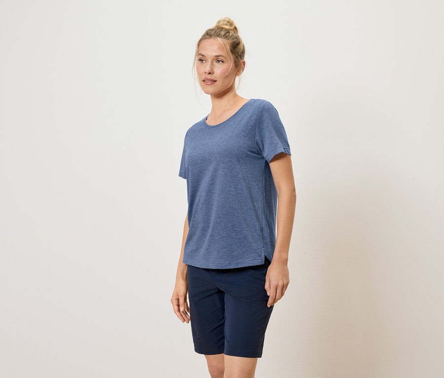 Femme avec un chignon portant un t-shirt bleu et un short bleu.