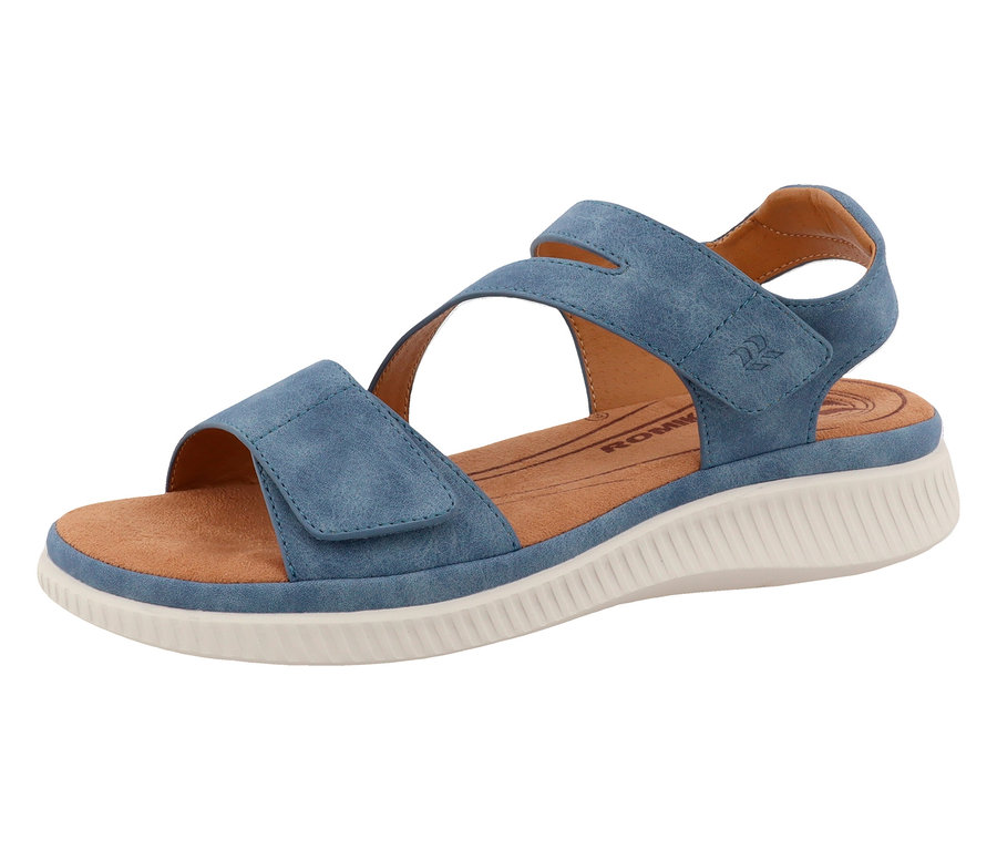 Une unique sandale bleue à brides avec fermeture velcro posée sur une surface blanche.