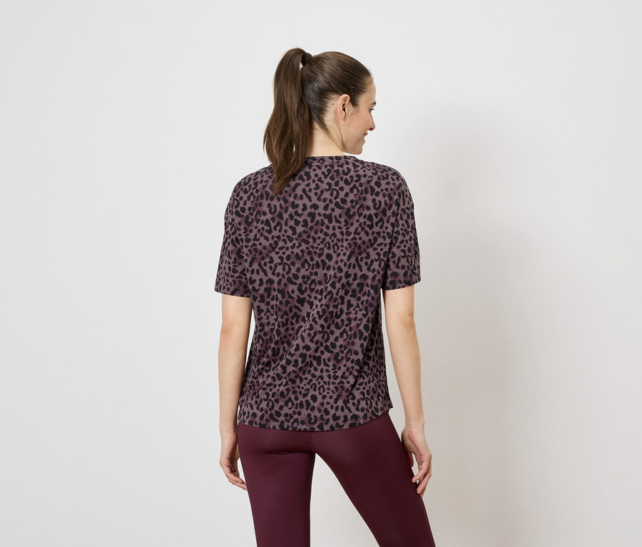 Vue arrière d'une femme avec une queue de cheval portant un t-shirt léopard marron et un legging bordeaux.
