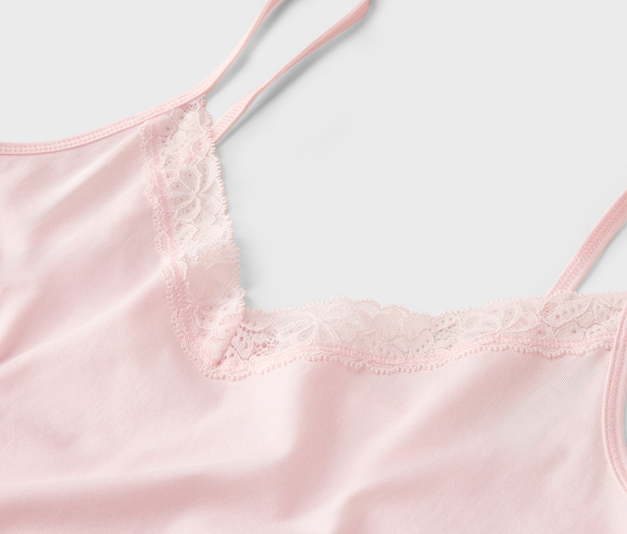 Gros plan d'un débardeur rose avec des détails en dentelle.