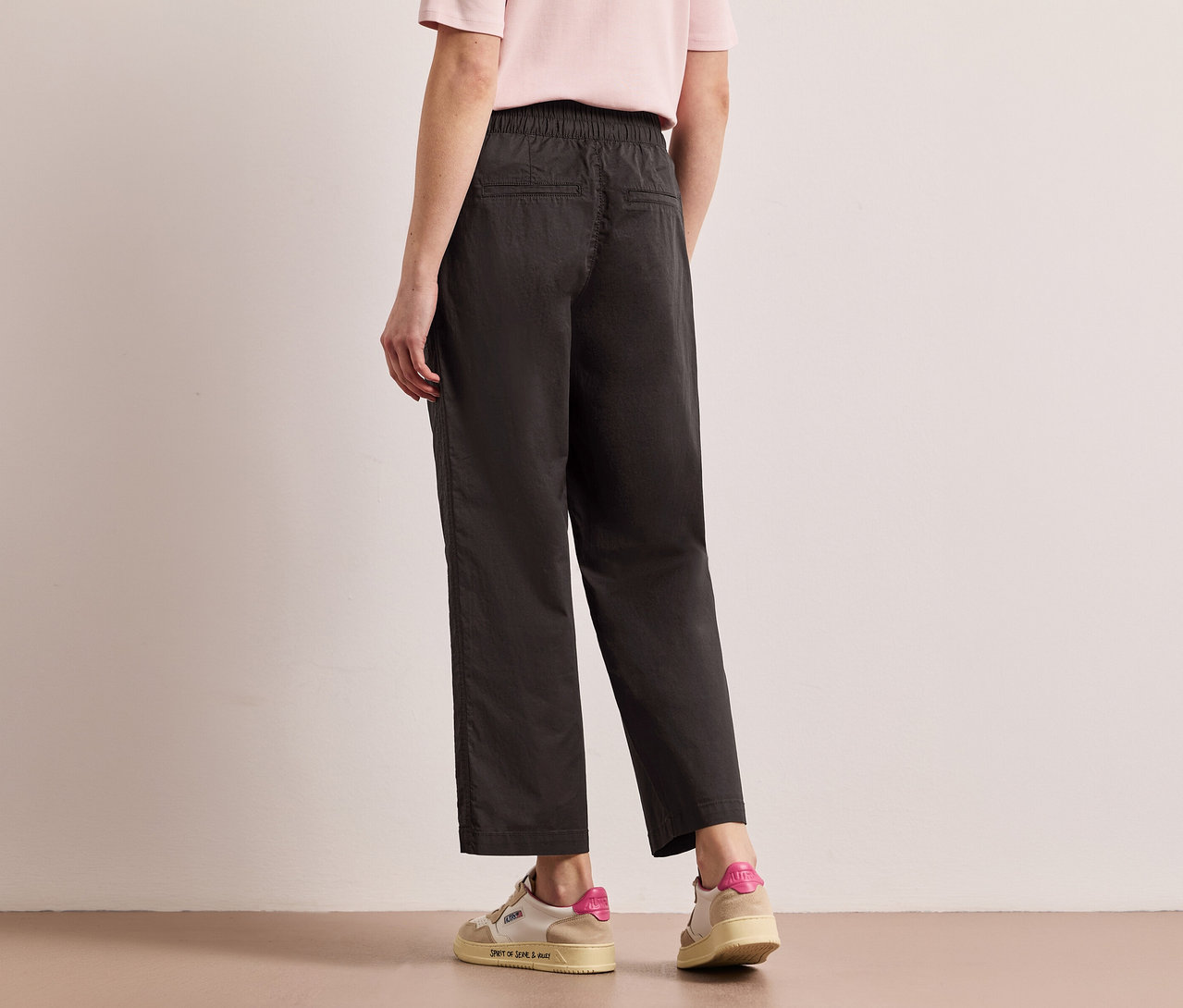 Femme vue de dos portant un pantalon Street One Papertouch noir et des baskets.