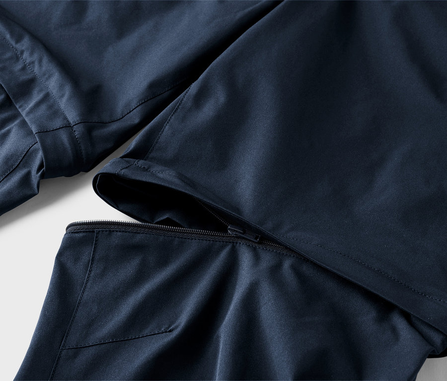 Gros plan sur un pantalon bleu marine dont une jambe peut être retirée par une fermeture éclair.