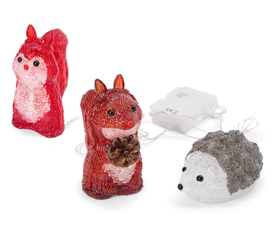 Deux figurines d'écureuils rouges translucides et un hérisson blanc-gris translucide, connectés par de fins fils à un boîtier de piles blanc. Un écureuil tient une pomme de pin.