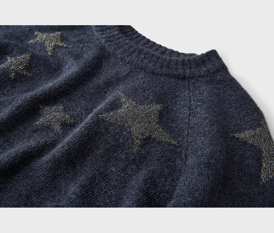 Pull en maille bleu foncé avec des motifs d'étoiles dorées scintillantes et un col côtelé.