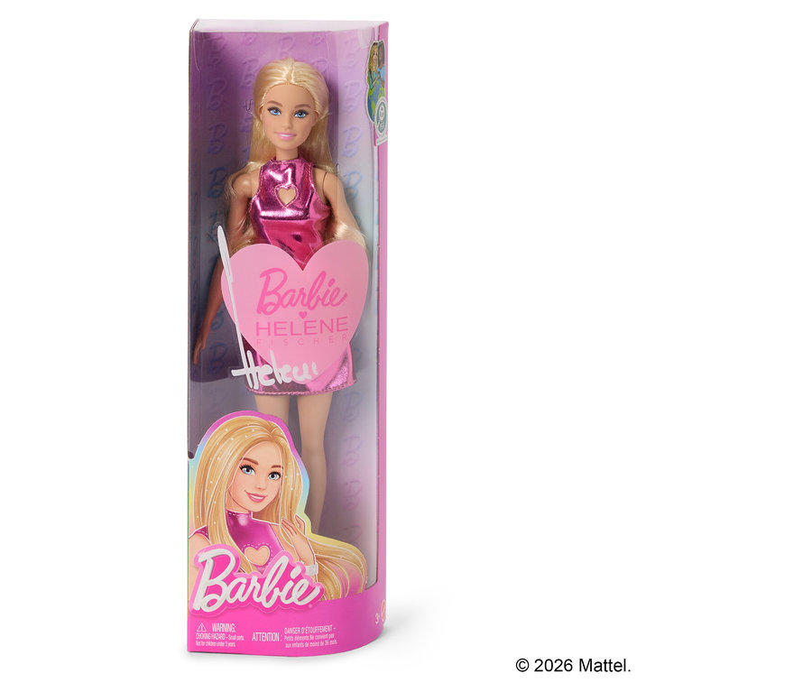 Une poupée Barbie Helene Fischer dans un emballage transparent. La poupée a les cheveux blonds et porte une robe rose brillante. L'emballage indique « Barbie Helene Fischer ».