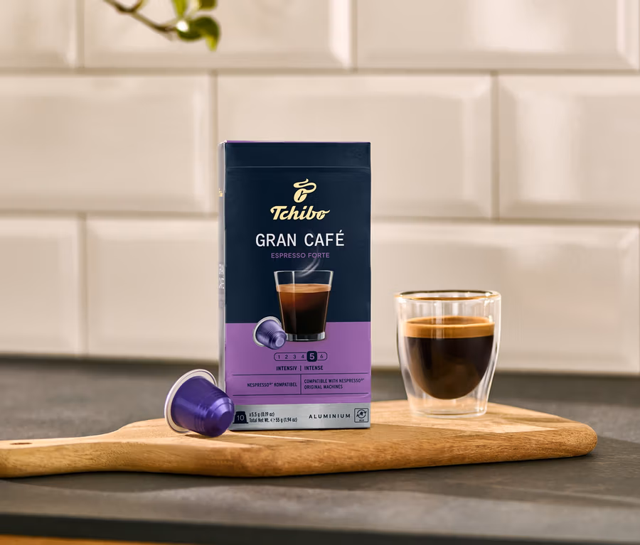 Un paquet de capsules Gran Café Espresso Forte à côté d'une tasse à expresso sur une planche.