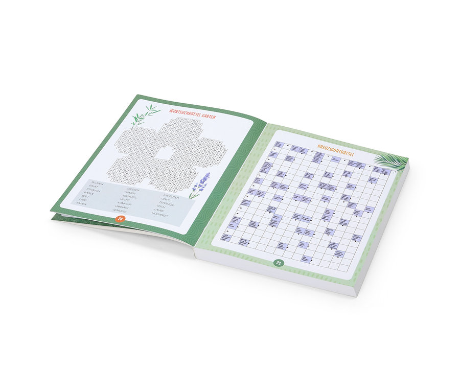 Cahier de puzzles ouvert avec des mots cachés et des mots croisés sur le thème du jardin.