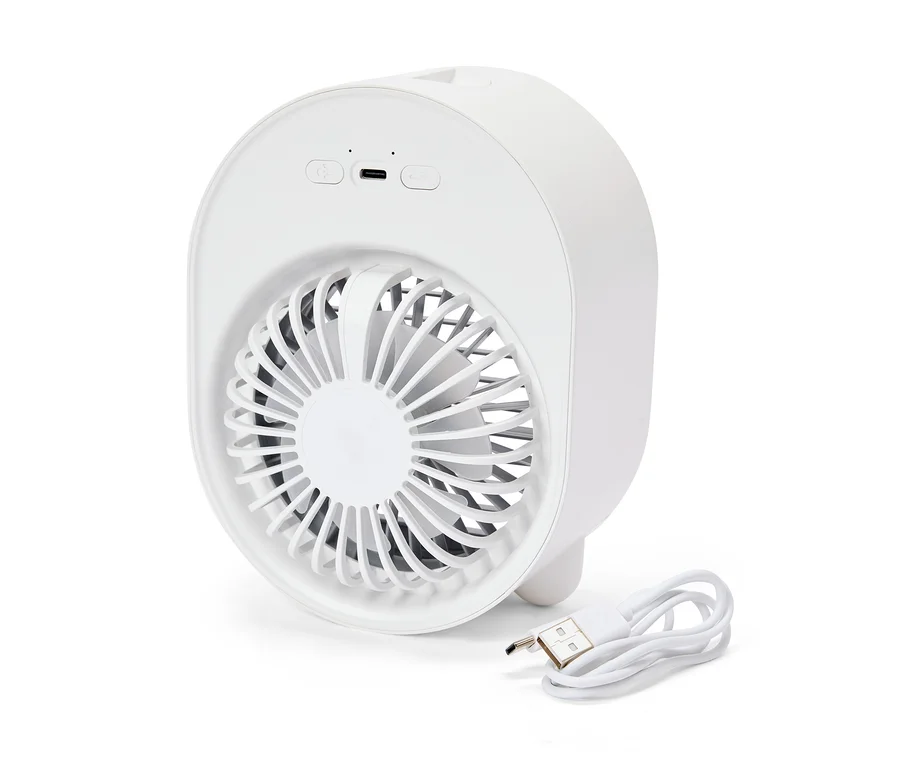 Un mini ventilateur blanc et rond est posé à côté d'un câble USB.