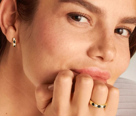 Femme portant une bague Noir et Blanc, une chaîne et des créoles Noir et Blanc.