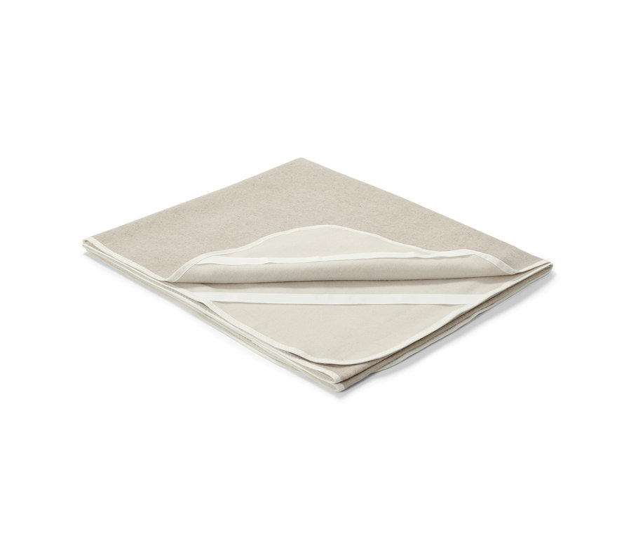 Un surmatelas beige avec du lin, d'environ 180 x 200 cm, est plié sur un fond blanc.