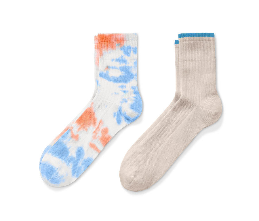 Deux paires de chaussettes : une paire blanche avec un motif tie-dye orange et bleu, et une paire beige.