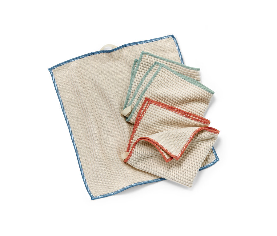 Trois chiffons de nettoyage universels beiges avec des bordures colorées sont posés les uns sur les autres.