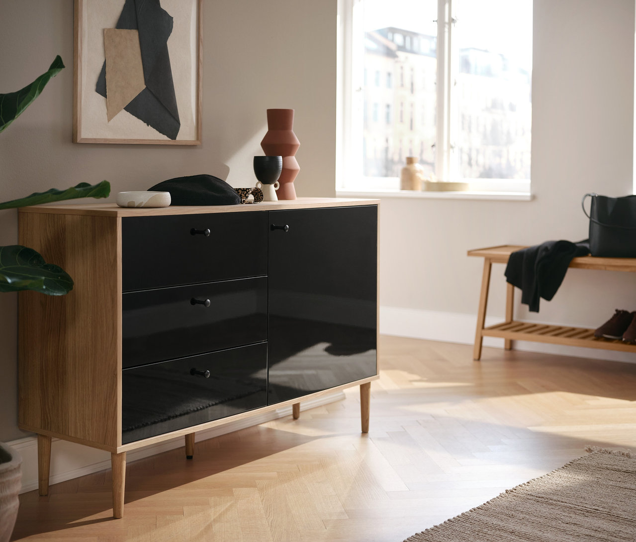 Une commode anthracite »Bekeson« et un banc avec rangement sont présents dans la pièce.