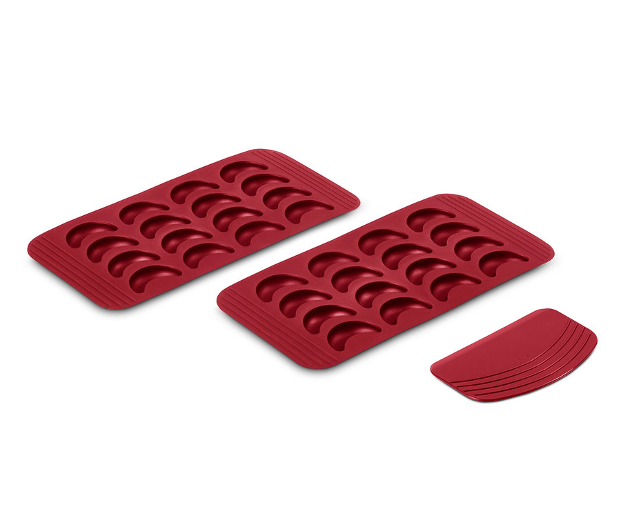 Deux feuilles de cuisson rouges pour croissants vanillés et un emporte-pièce.