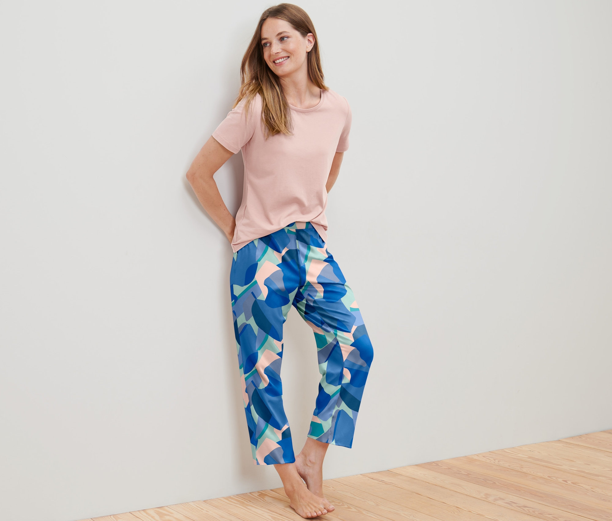 Femme appuyée contre un mur en pyjama.