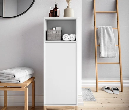 Dans la salle de bain, il y a une armoire de salle de bain et un tabouret.