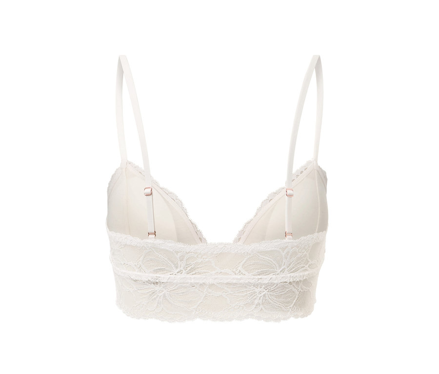Détail d'une brassière en dentelle blanche avec bretelles réglables.