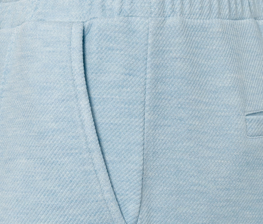Gros plan sur un pantalon de jogging bleu clair avec nervure et poche.
