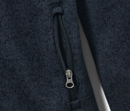 Détail d'une veste en maille polaire pour enfant avec poche zippée.