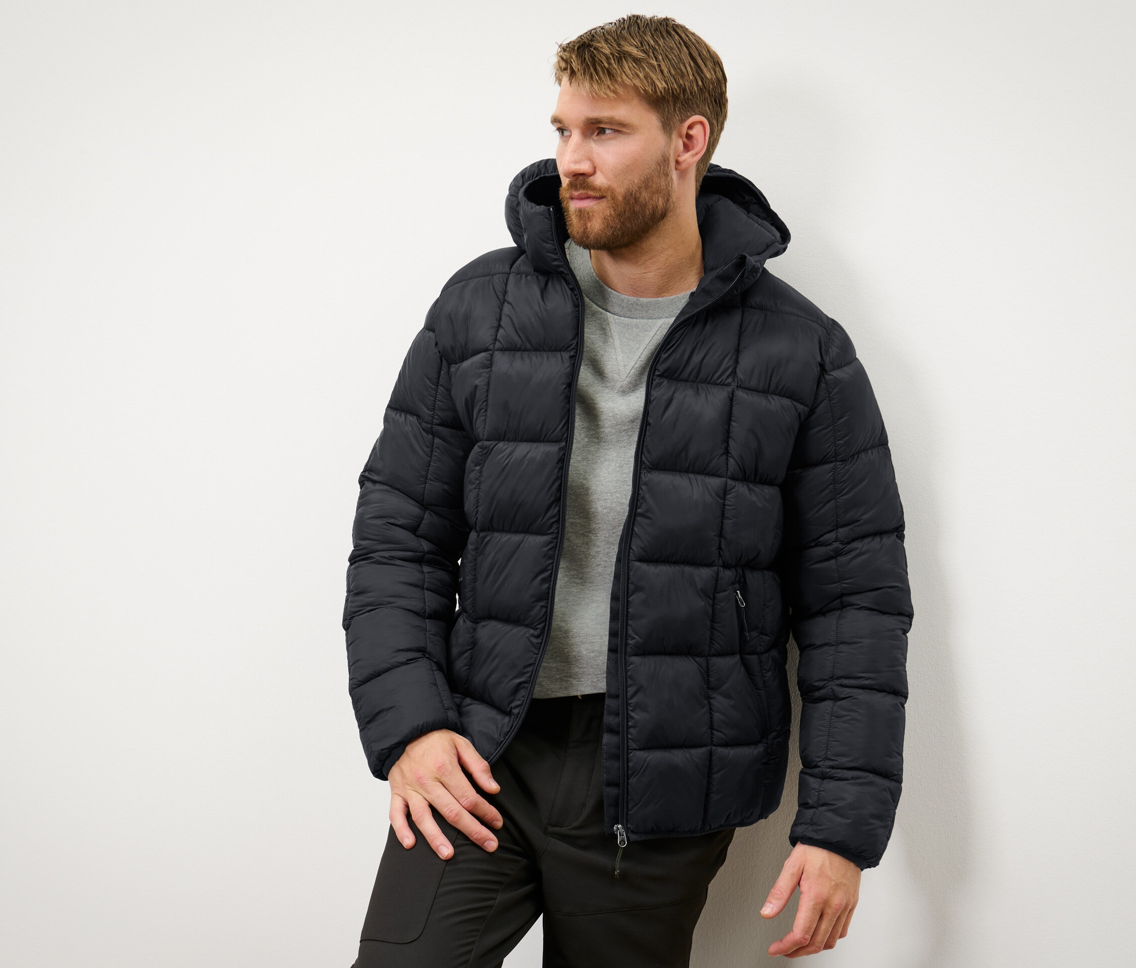 Un homme portant une veste matelassée noire.