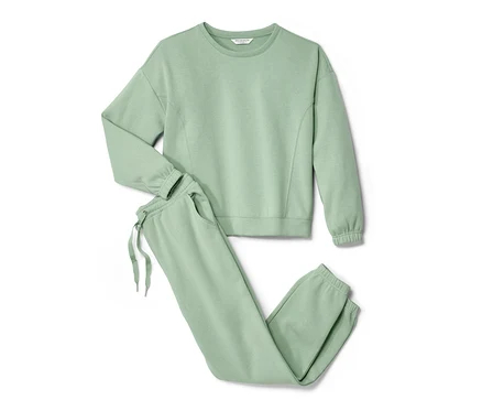 Un survêtement d’intérieur vert avec un sweat-shirt et un pantalon de jogging posé sur un fond blanc.