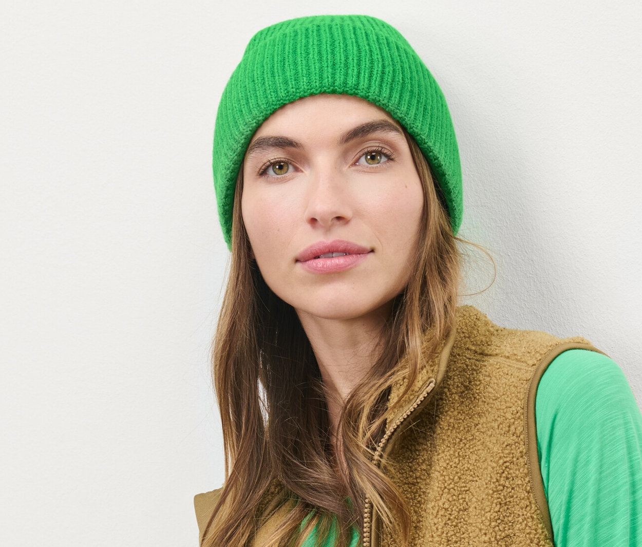 Femme portant un bonnet en maille vert.