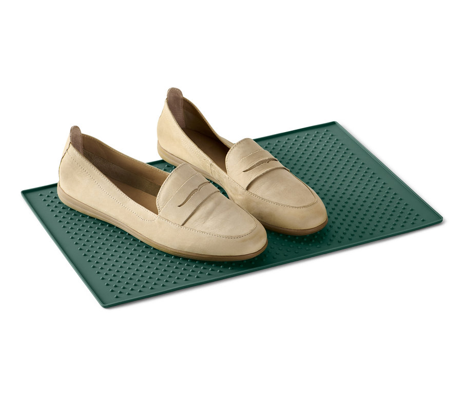 Deux mocassins beige sur un dessous de gamelle vert.