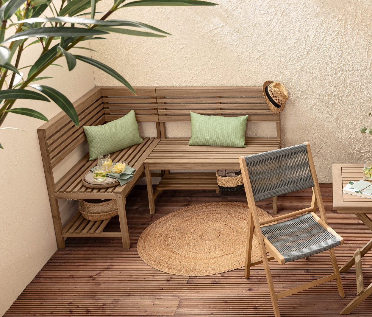 Coin salon avec table pliante « Lenja », banc d’angle flexible « Lenja », 2 coussins d’extérieur et 2 colonnes à plantes « Tinus ».