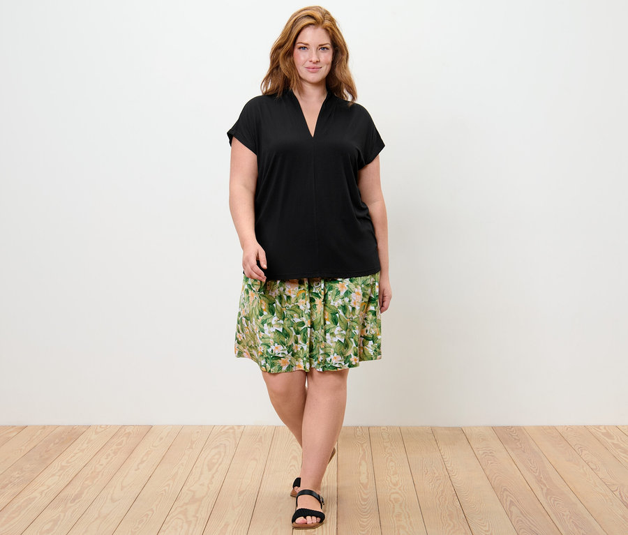 Femme portant une blouse avec encolure en V et une robe en jersey imprimée.
