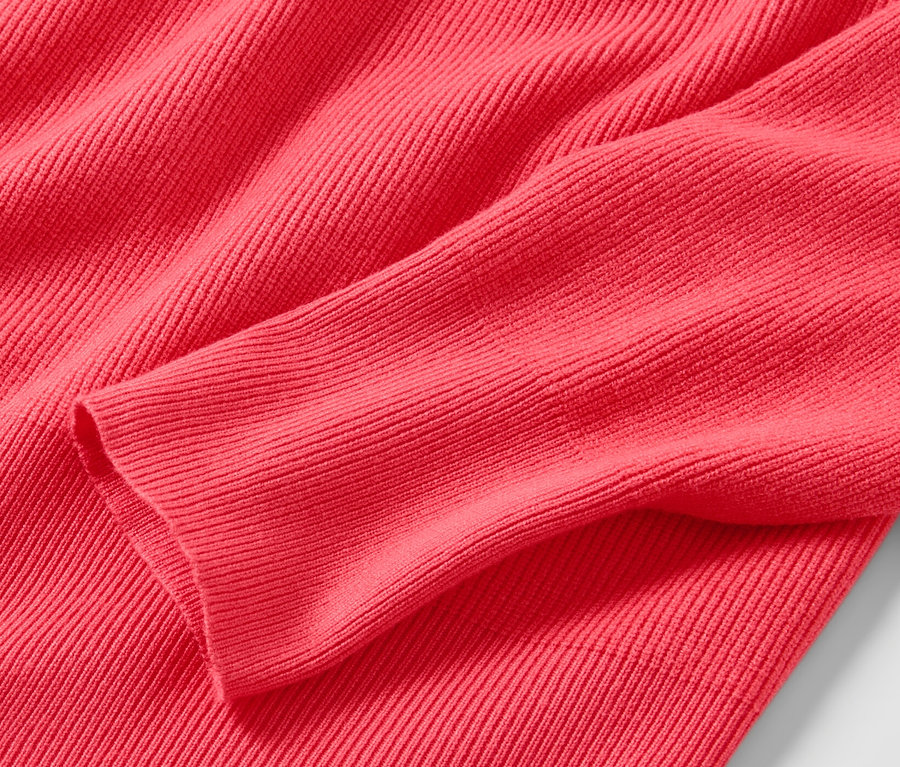 Gros plan d'un pull en maille fine rouge.