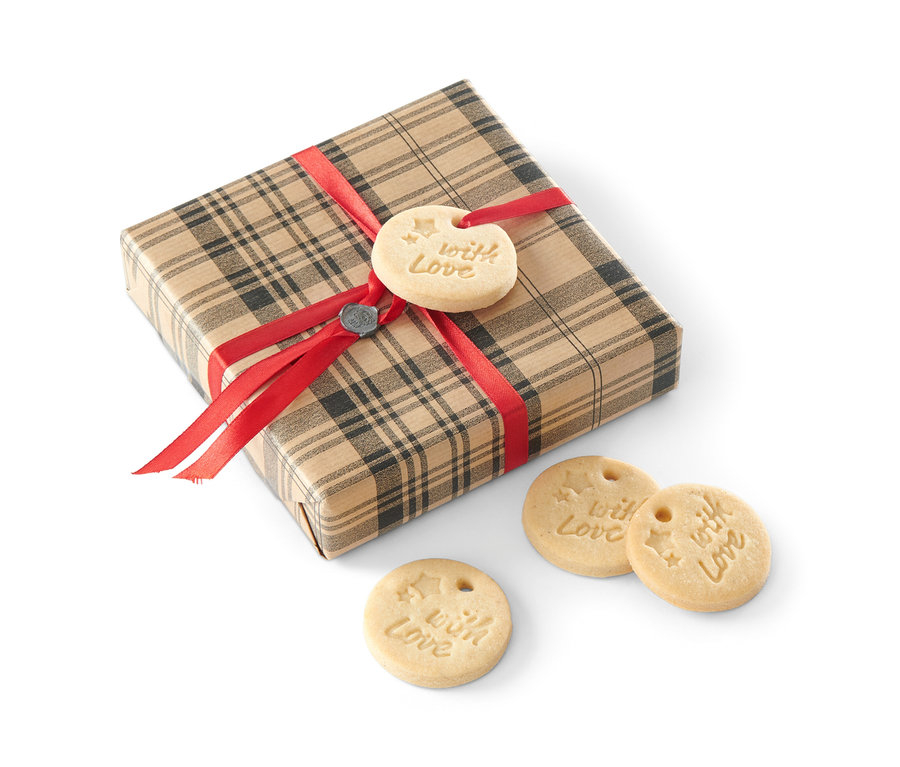 Un paquet cadeau avec un ruban rouge et des biscuits avec l'inscription "With Love".