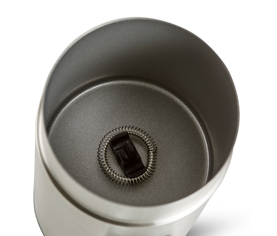 Vue de dessus d'un mousseur à lait électrique en inox avec un fouet à l'intérieur.