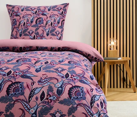 Parure de lit en jersey hivernal taille normale avec motif floral sur un lit.