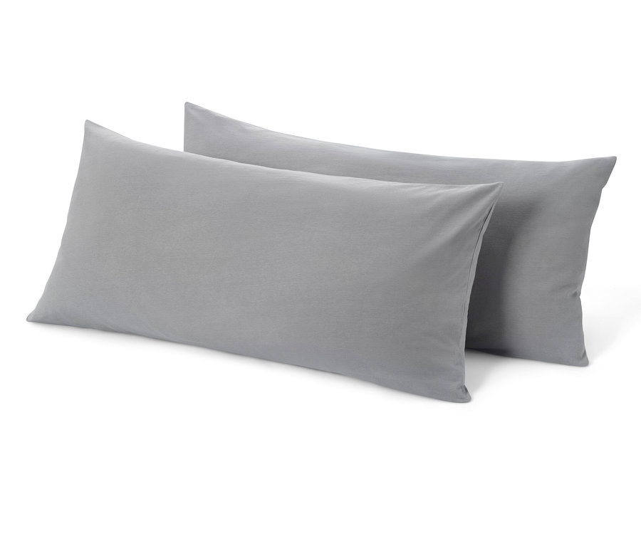 Deux taies d'oreiller en jersey gris sont posées l'une à côté de l'autre.