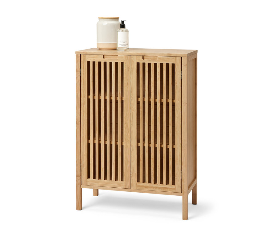 Un buffet en bambou avec deux portes. Un pot et un distributeur de savon sont posés sur le buffet.