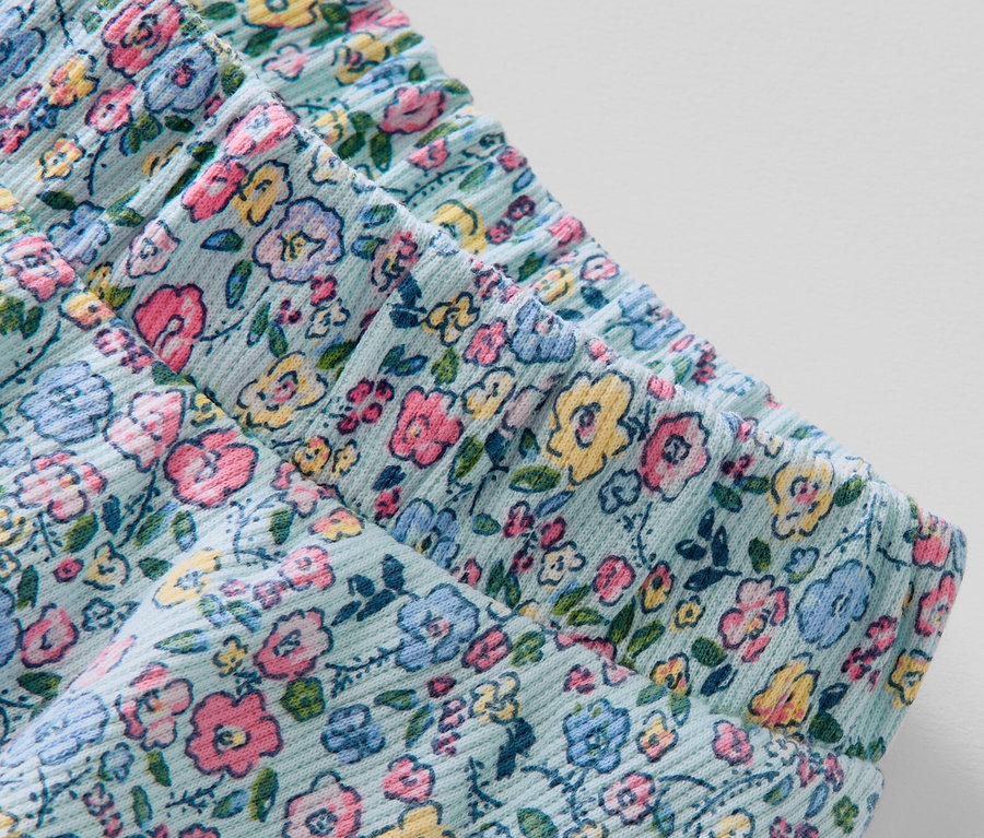 Détail d'une jupe pour enfant avec pantalon à motif floral.