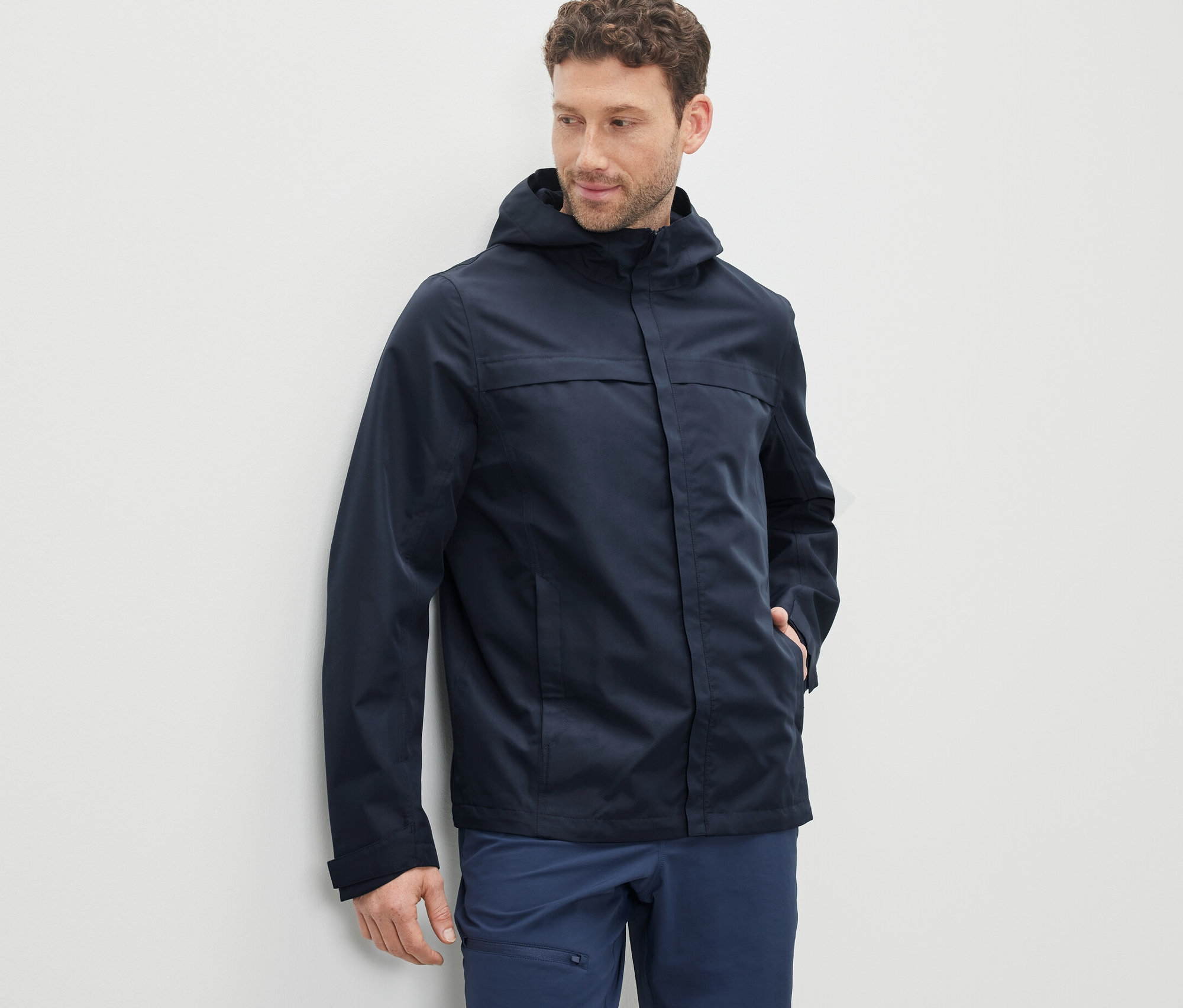 Un homme portant une parka technique bleu marine.