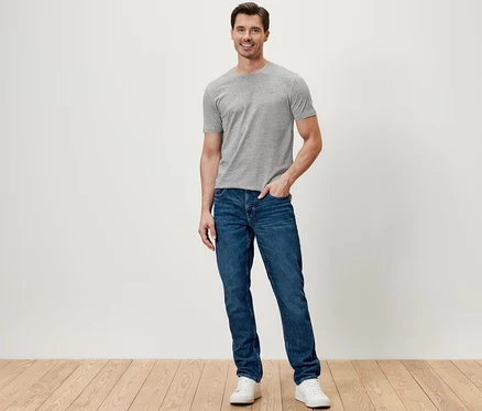 Un homme debout portant un jean.