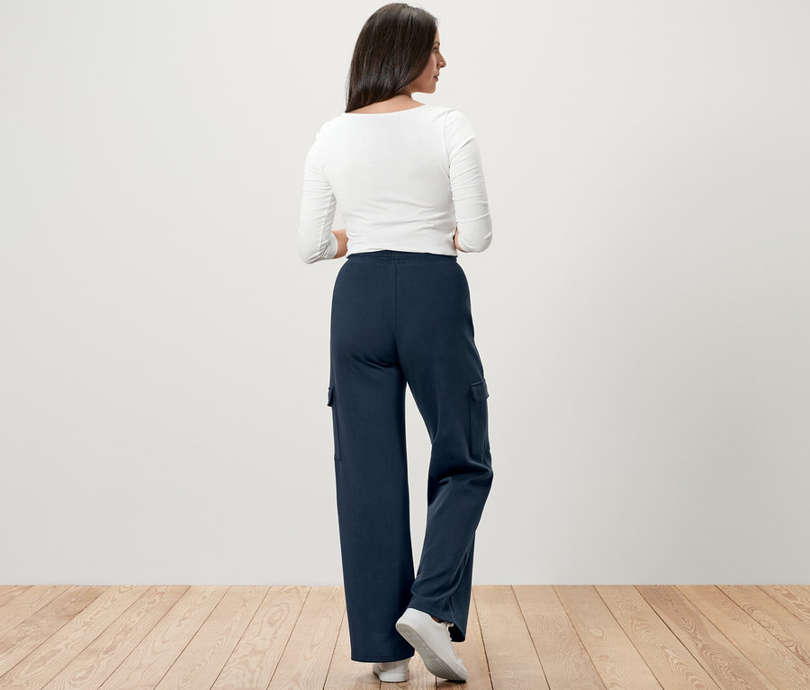 Une femme, vue de dos, porte un pantalon molletonné bleu foncé avec des poches cargo.