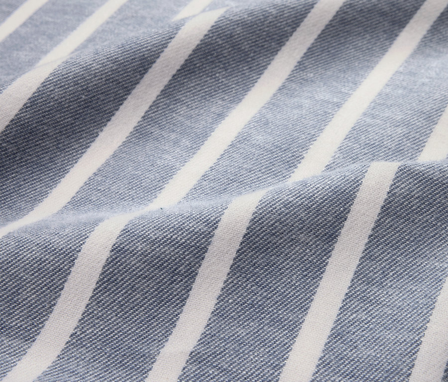 Gros plan d'une parure de lit en flanelle bleue rayée, grande taille.